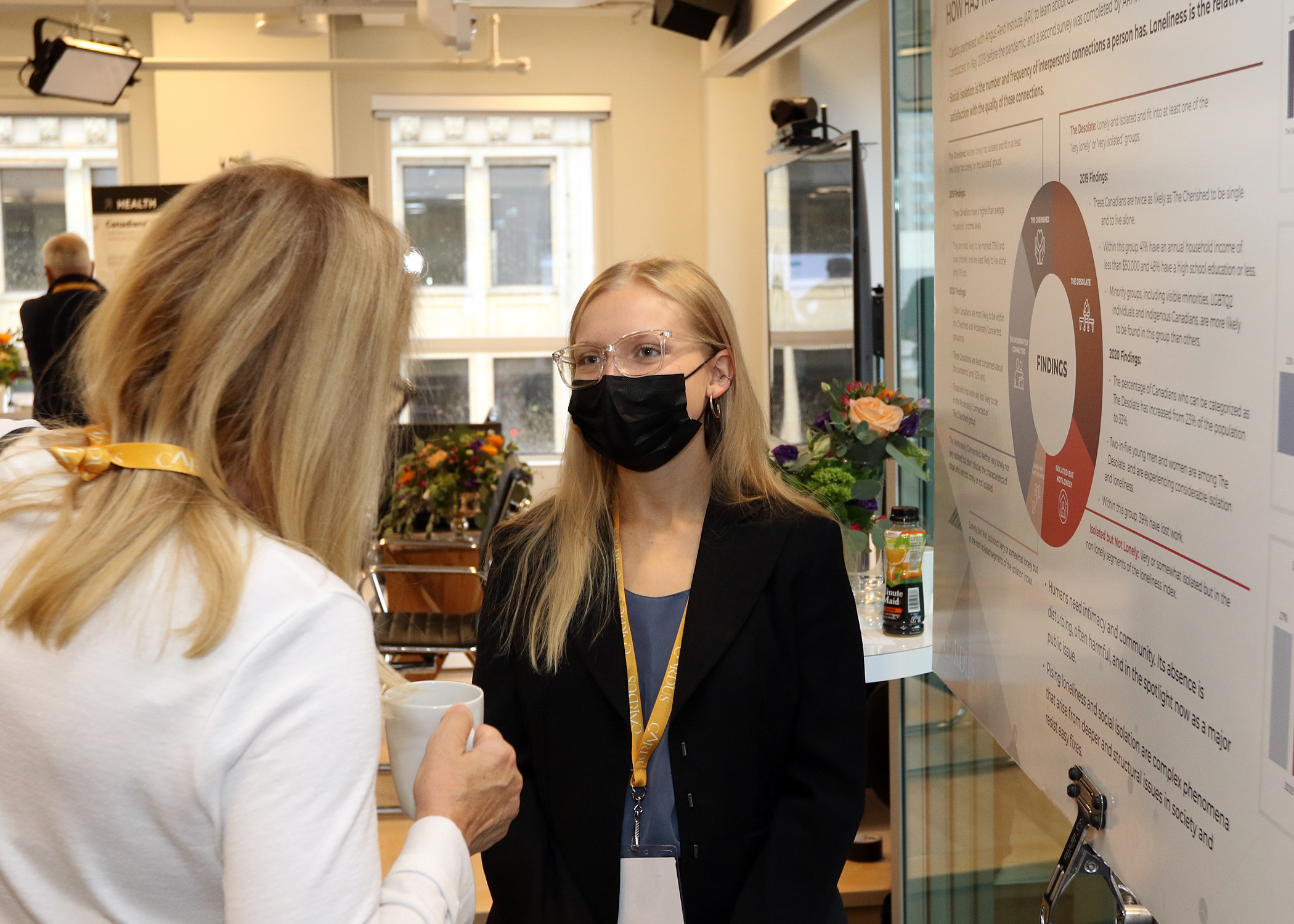 Masked young professional speaking to a colleague