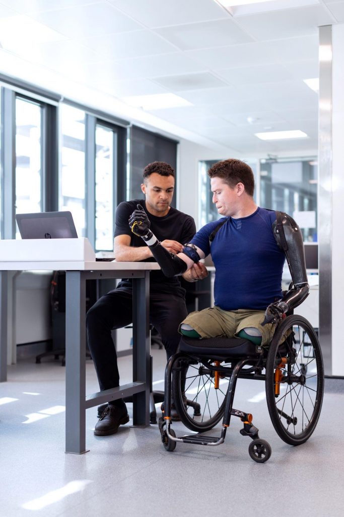 Man in wheelchair being fit for prosthetics