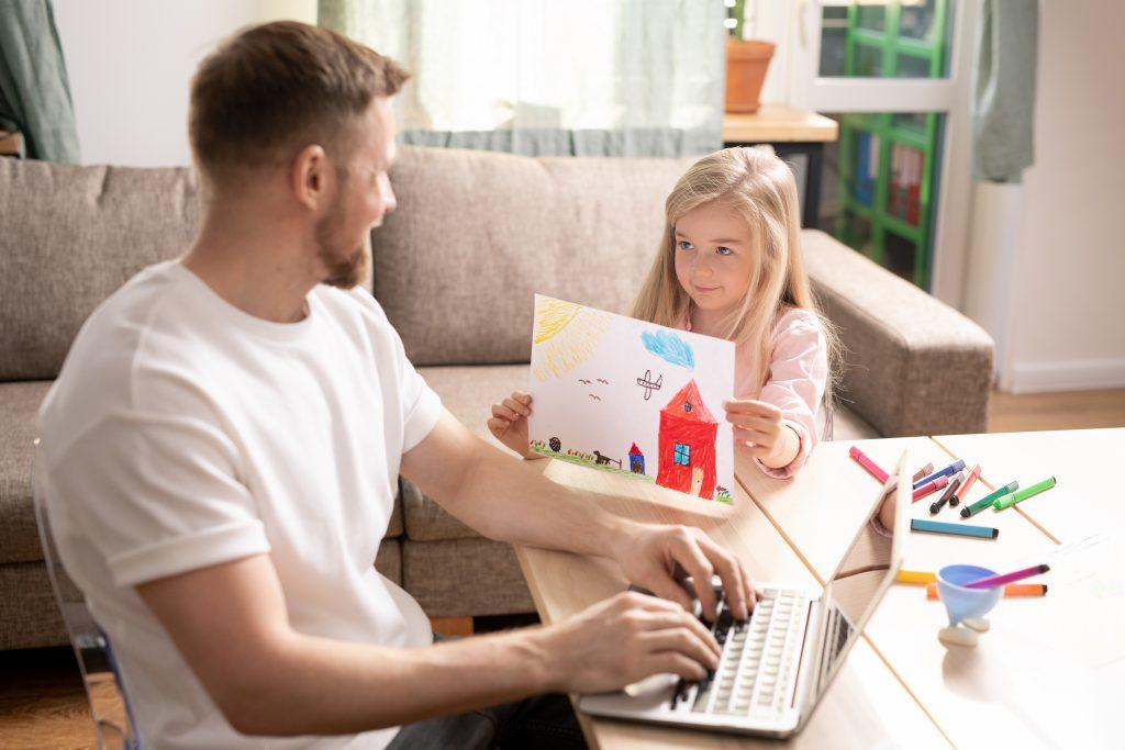 Little girl shows picture she drew to father