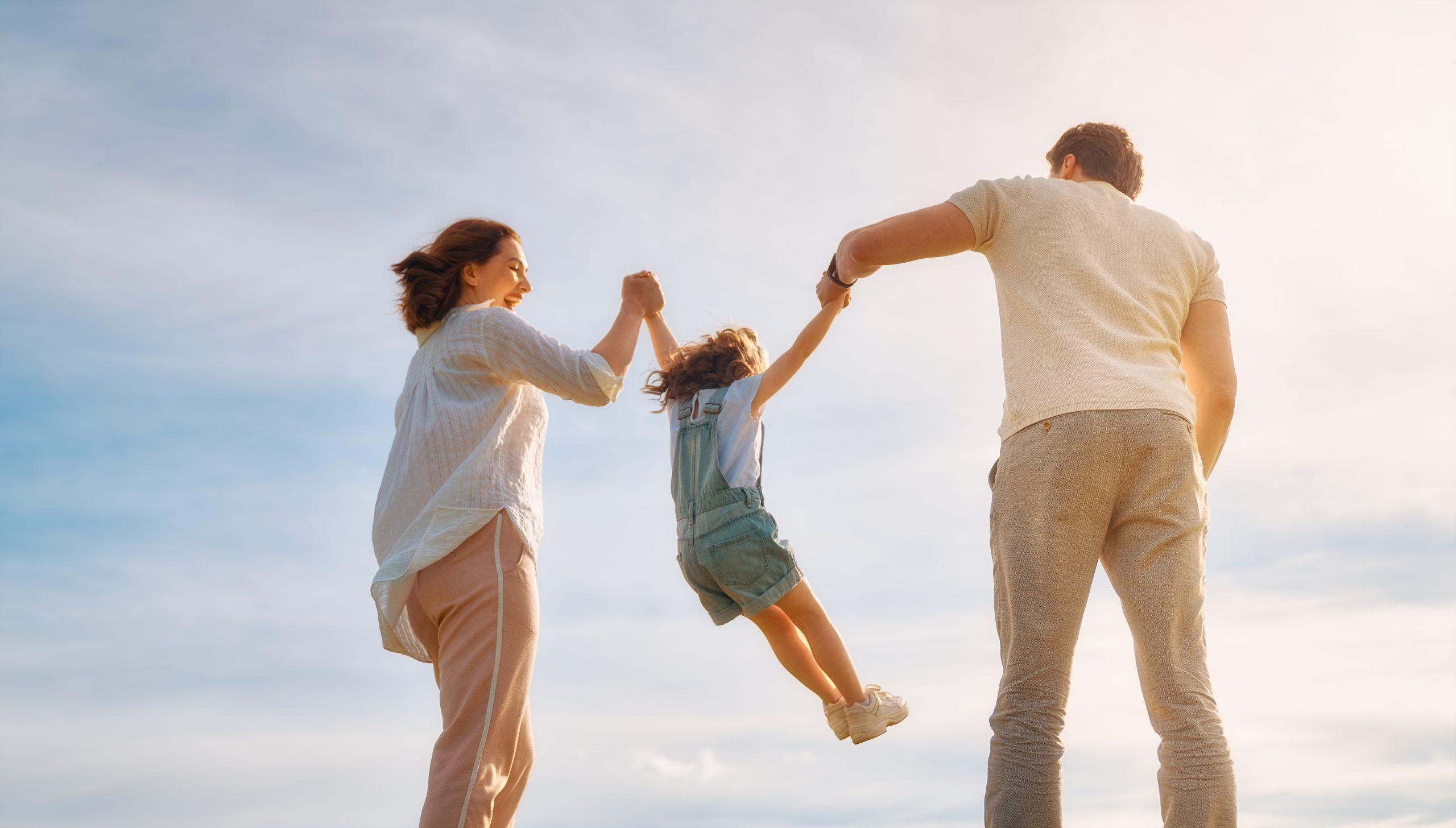 Happy family on summer walk! Mother, father and daughter walking in the Park and enjoying the beautiful nature.